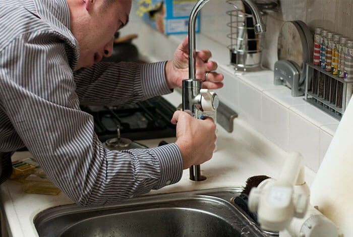 artisan plombier réparant un robinet